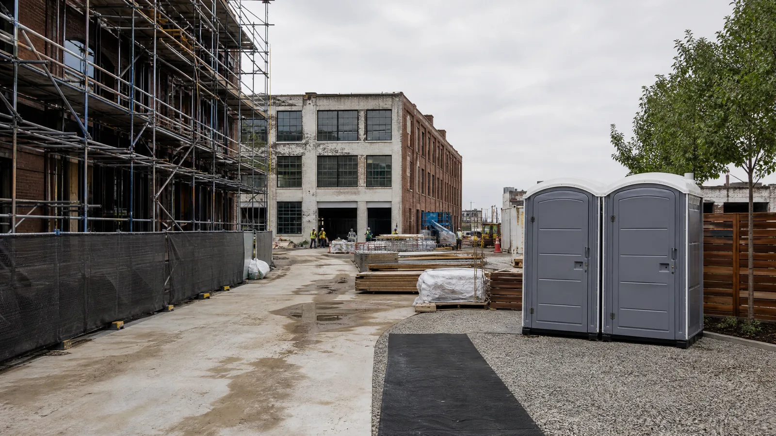 Urban New York construction site with fenced work area and an organized temporary worker-support zone